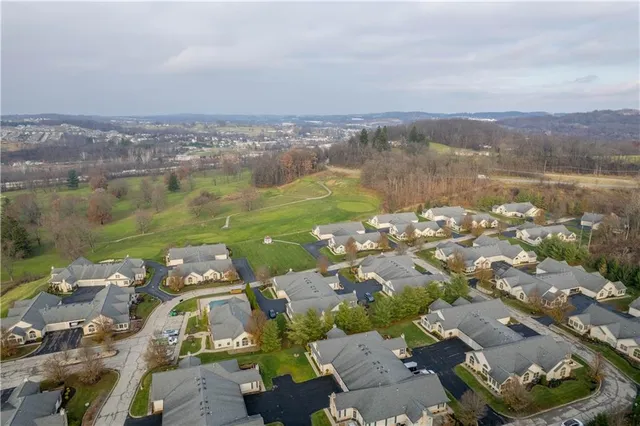 an aerial view of a city with lots of residential buildings ocean and mountain view in back