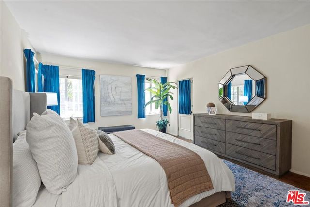 a bedroom with a bed and a mirror on dresser