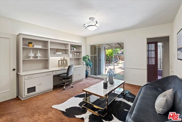 a view of a livingroom with workspace and a window