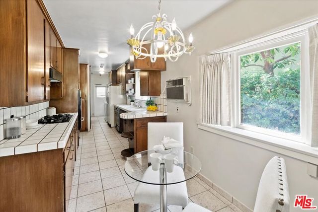 a dining room with wooden floor a chandelier a wooden table and chairs
