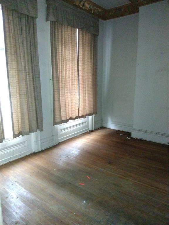 1005 Sheffield Street Pittsburgh, PA 15233 - Photo 6 of 25 an empty room with wooden floor and windows with curtains