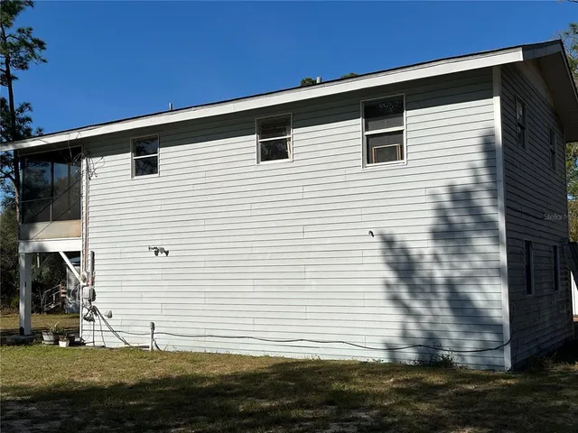 a view of a livingroom with a chandelier fan and a window