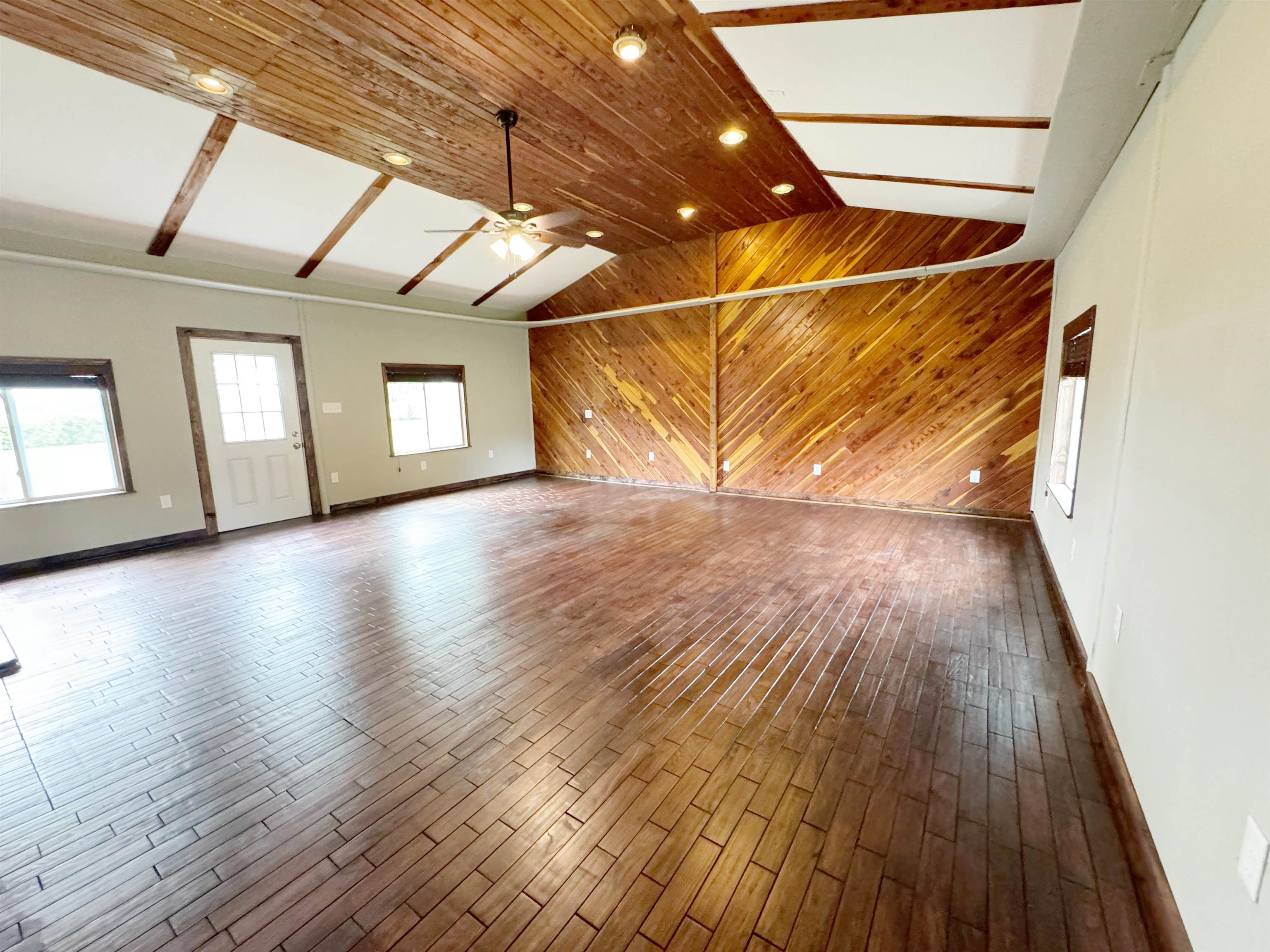 951 Sloan Road Burlison, TN 38015 - Photo 13 of 29 a view of an empty room with wooden floor and windows