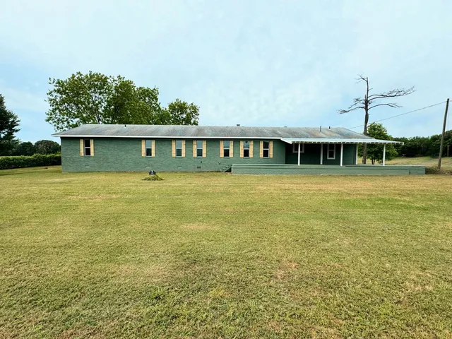 a view of swimming pool with lawn chairs and plants