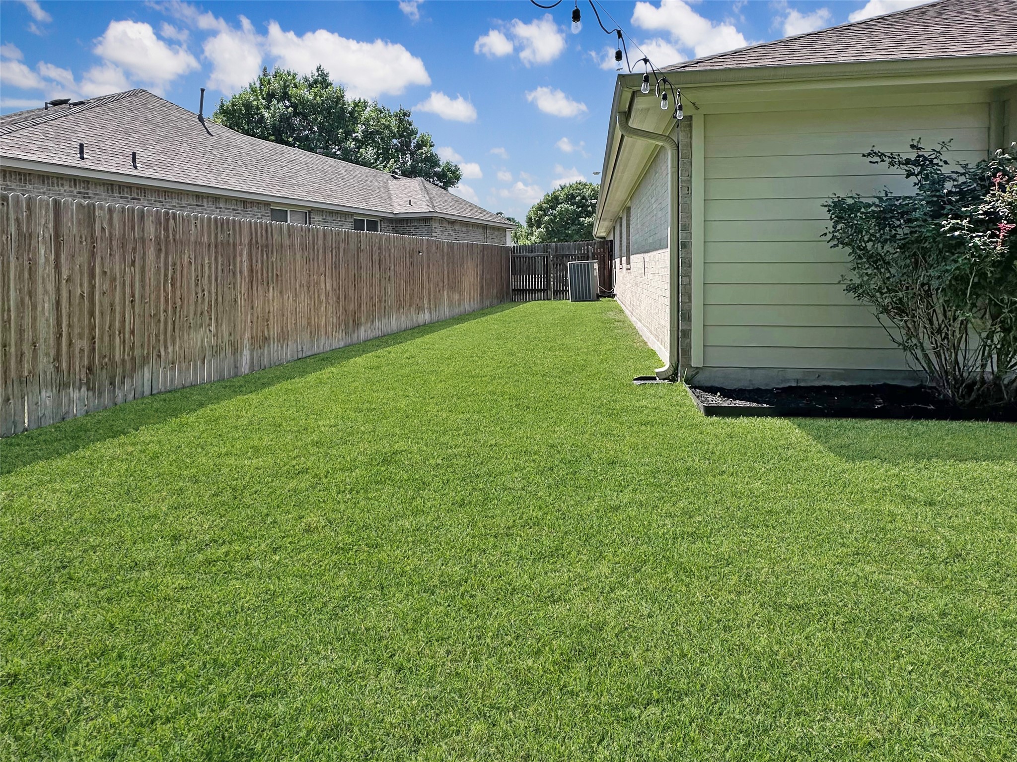 20213 Kearney Hill Road Pflugerville, TX 78660 - Photo 27 of 27 A well-maintained lawn offers ample space for outdoor activities, bordered by a robust privacy fence.