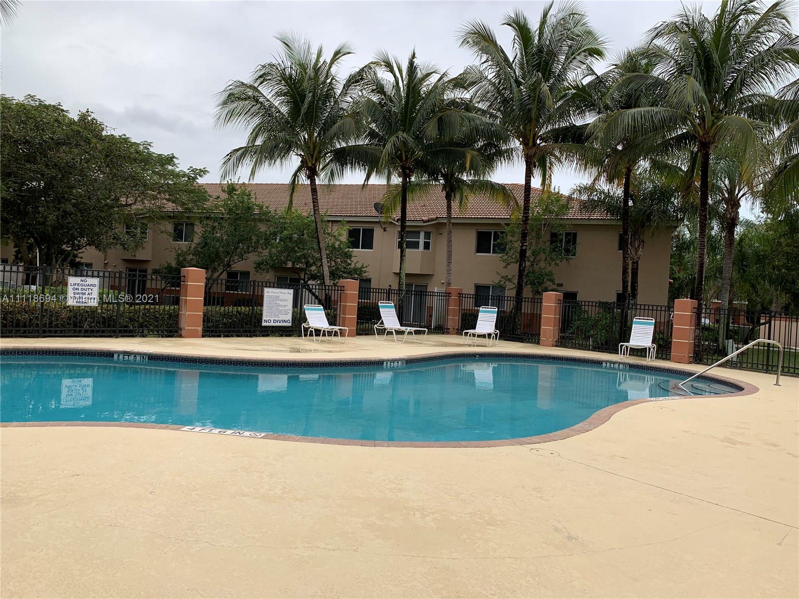 3770 North Jog Road, Unit 103 West Palm Beach, FL 33411 - Photo 15 of 15 a view of a swimming pool with a table and chairs