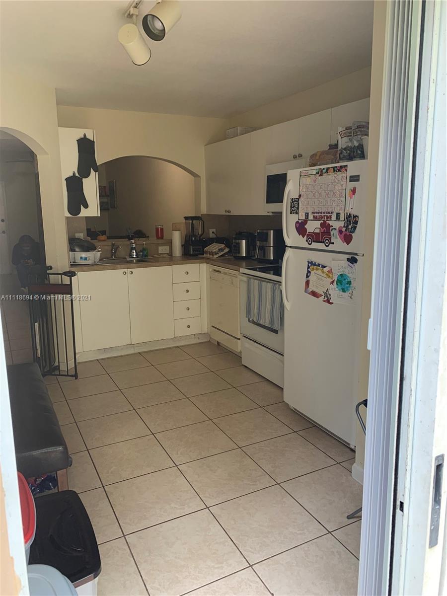 3770 North Jog Road, Unit 103 West Palm Beach, FL 33411 - Photo 5 of 15 a kitchen with a refrigerator and cabinets