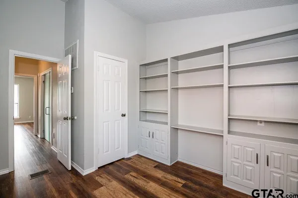 a view of empty room with wooden floor