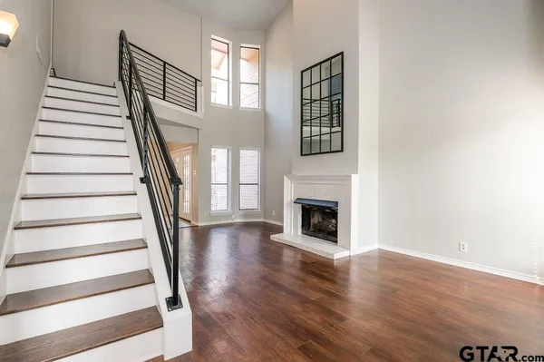 a view of a livingroom with wooden floor and a fireplace