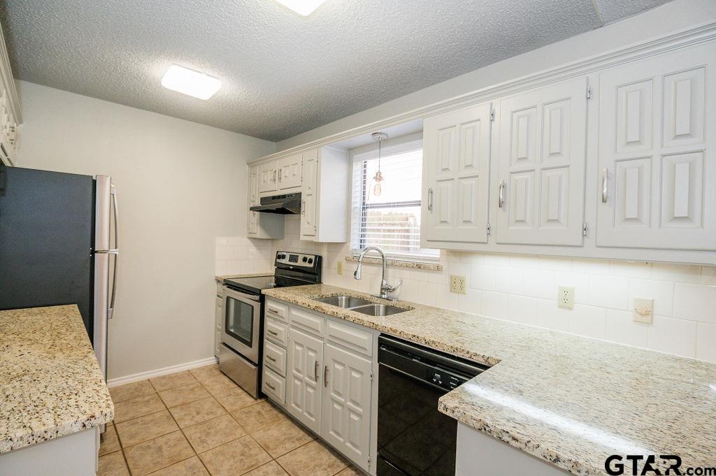 5809 Hollytree Drive Tyler, TX 75703 - Photo 32 of 32 a kitchen with a sink stove and cabinets