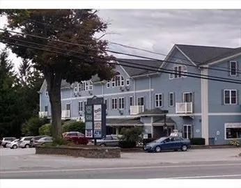 a front view of a building with lots of trees