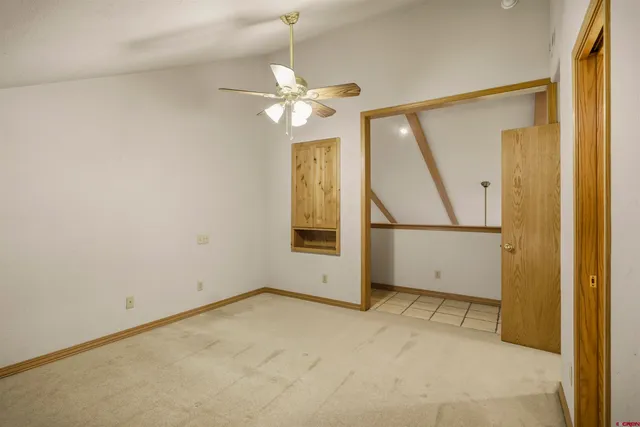 an empty room with fan and windows