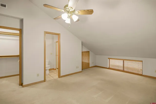 an empty room with chandelier fan