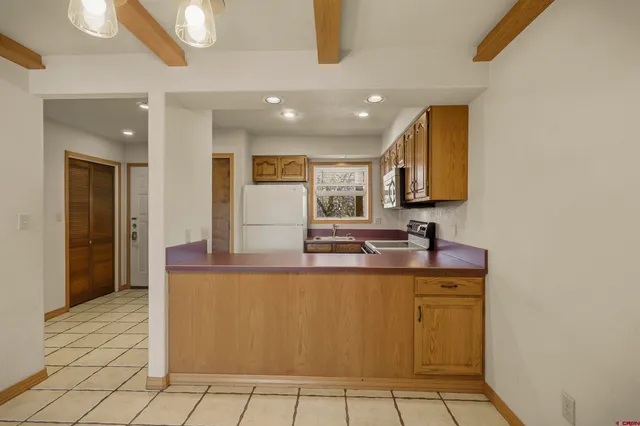 a view of a kitchen with kitchen island granite countertop a sink and cabinets