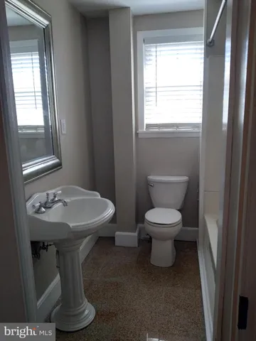 a bathroom with a toilet sink and mirror