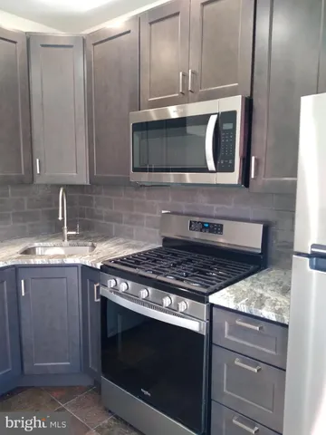 a stove top oven sitting inside of a kitchen