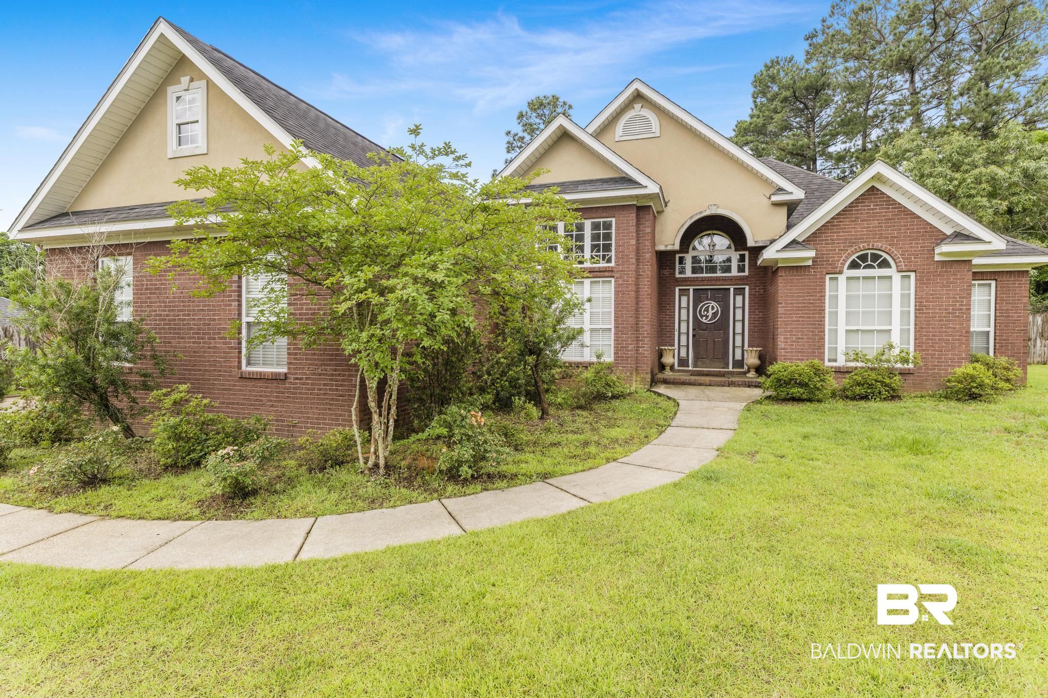 35814 Delvan Lane Bay Minette, AL 36507 - Photo 44 of 53 Brick and stucco exterior featuring an arched entry, a decorative front door, multiple gables, and a curved concrete walkway