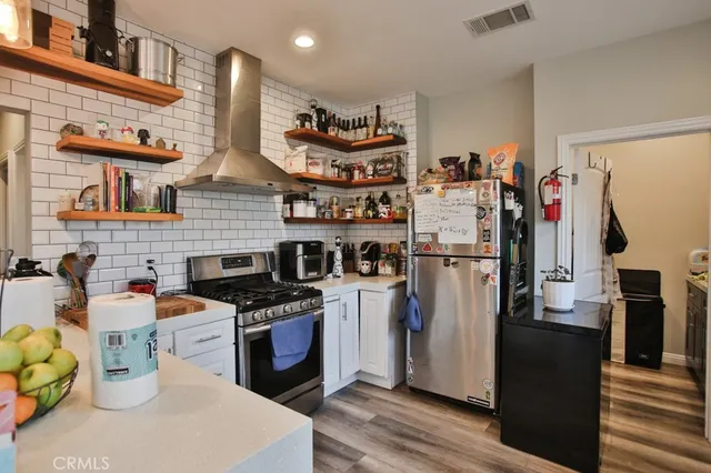 a kitchen with stainless steel appliances granite countertop a refrigerator a stove and a sink