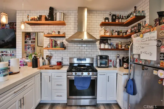 a kitchen with stainless steel appliances kitchen island granite countertop a stove and cabinets