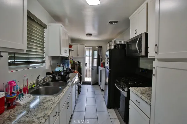 a kitchen with stainless steel appliances a stove refrigerator sink and cabinets