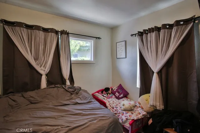 a bedroom with a bed a window and walk in closet