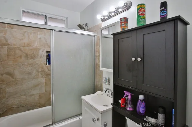 a bathroom with a sink vanity and a shower