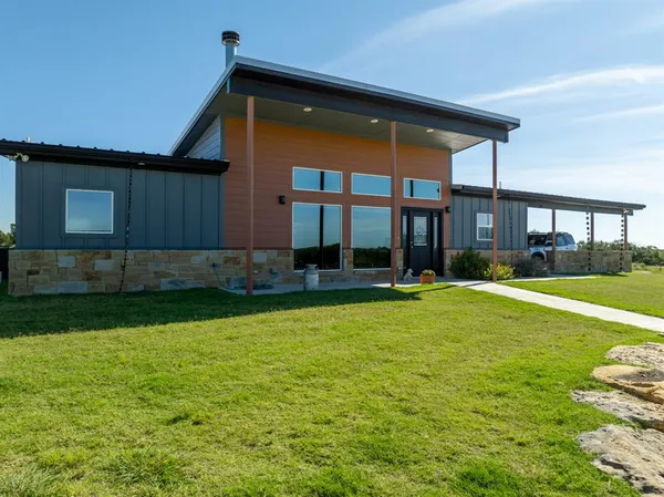 a front view of house with yard and outdoor seating