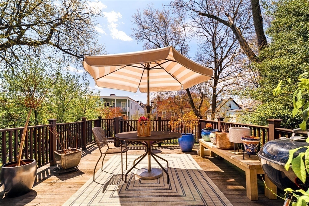 70 Oxford Street Somerville, MA 02143 - Photo 12 of 38 a view of a roof deck with couches and wooden fence