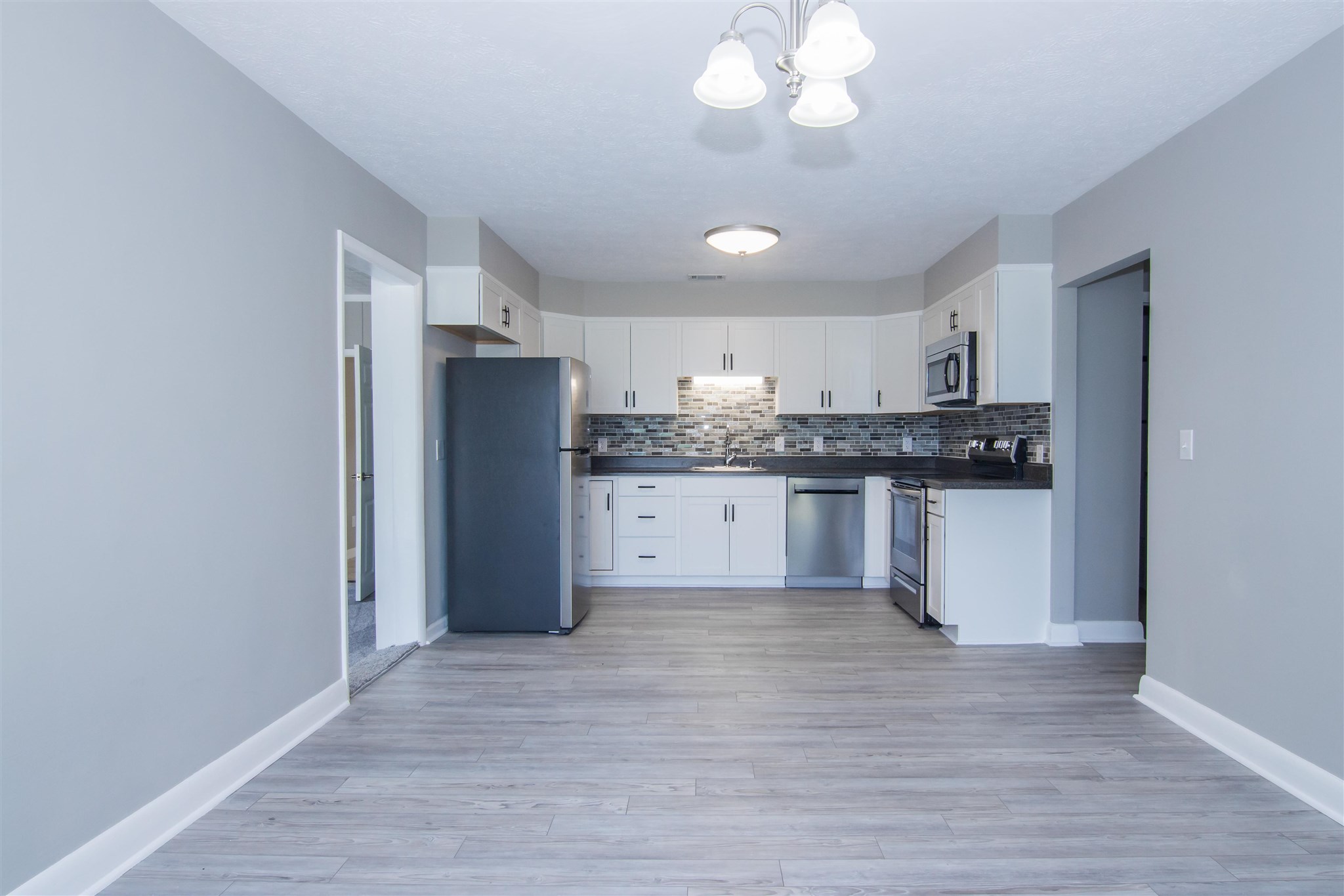 4133 Oak Ridge Road Mount Crawford, VA 22841 - Photo 11 of 30 a kitchen with stainless steel appliances granite countertop a refrigerator a sink dishwasher a stove and white cabinets with wooden floor
