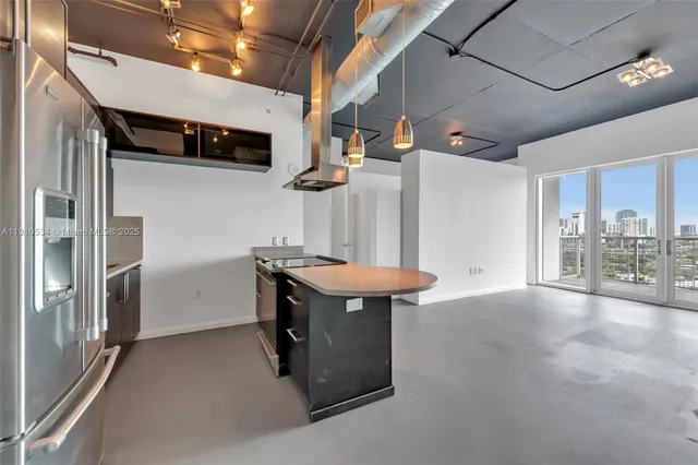 a view of a kitchen with stainless steel appliances wooden floor and a counter top space