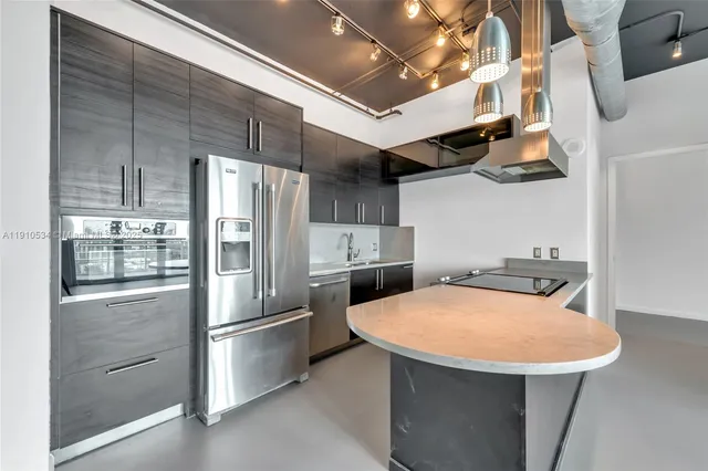 a kitchen with stainless steel appliances a refrigerator and a stove