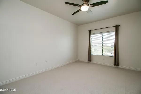 an empty room with a window and a fan