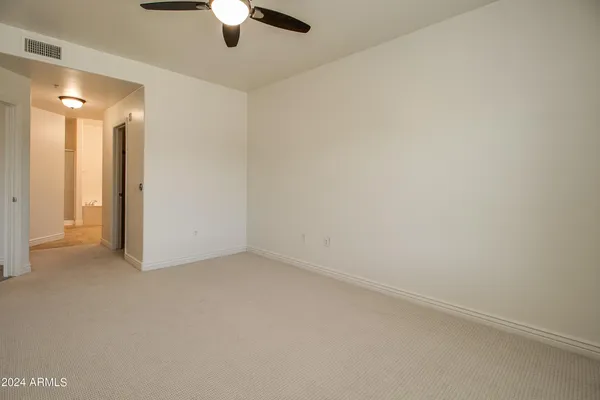 an empty room with a ceiling fan and a window