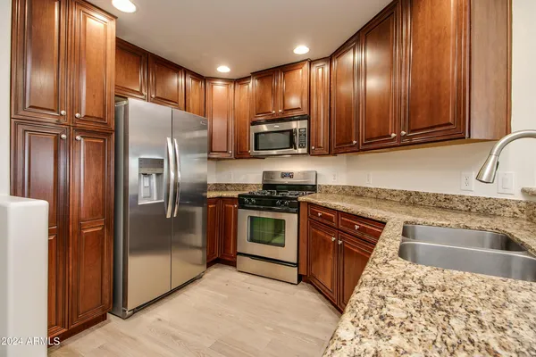 a kitchen with granite countertop stainless steel appliances and wooden cabinets