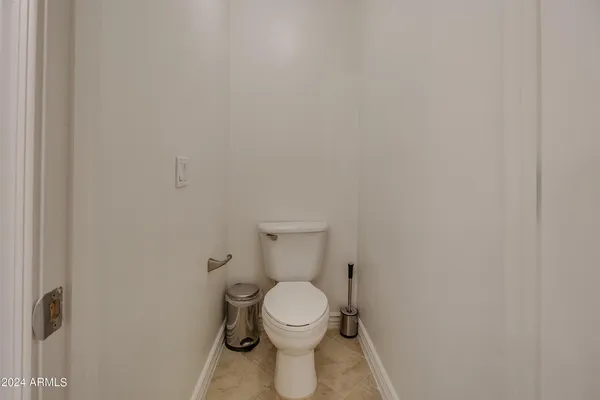 a white toilet sitting next to a white wall