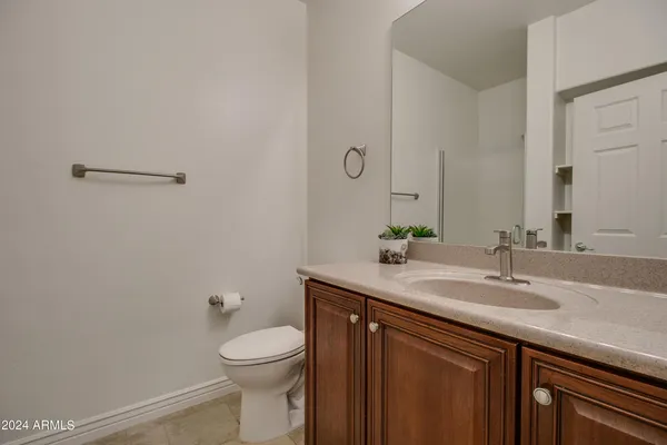 a bathroom with a granite countertop toilet sink and mirror