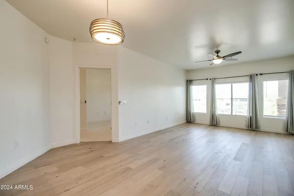 a view of a livingroom with wooden floor and a ceiling fan