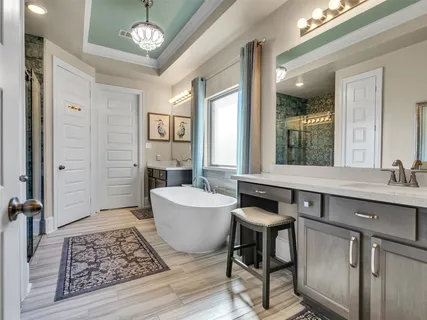 a spacious bathroom with a granite countertop sink a mirror and a bathtub