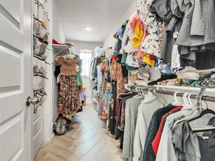 a view of walk in closet with clothes and shoes