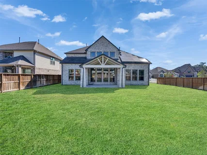 a view of a big house with a big yard and large trees