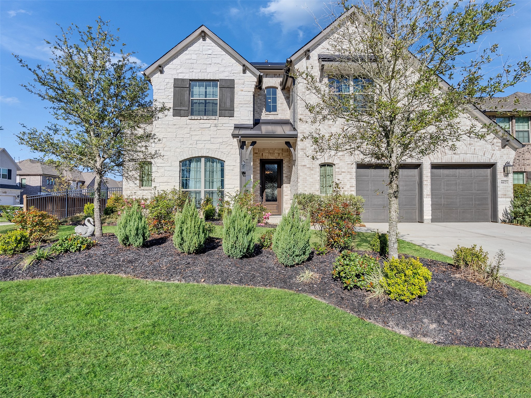 8673 Burdekin Road Magnolia, TX 77354 - Photo 6 of 48 a front view of a house with a garden and plants
