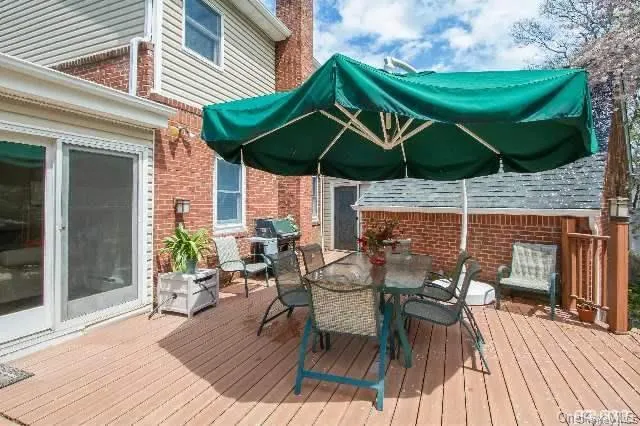 a view of a patio with table and chairs under an umbrella with wooden floor