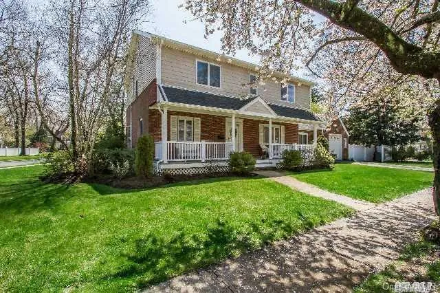 a front view of a house with a yard and green space