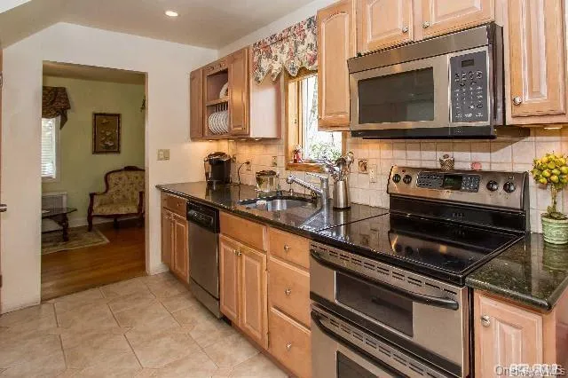 a kitchen with stainless steel appliances a stove a sink and a microwave