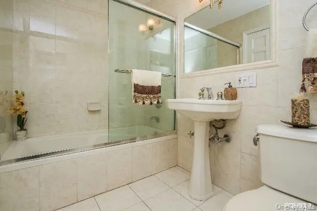a bathroom with a sink and mirror with bathtub