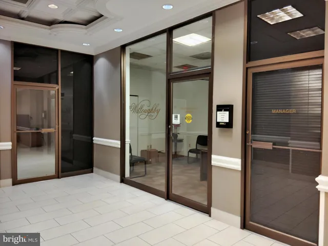 a room with lots of tables a large window and chairs