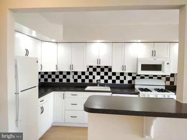 a kitchen with stainless steel appliances a refrigerator sink and microwave