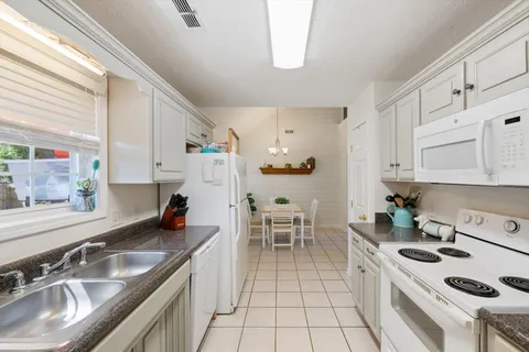 a kitchen with granite countertop a sink a stove and cabinets