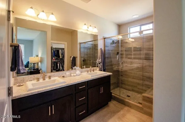 a bathroom with a double vanity sink mirror and shower