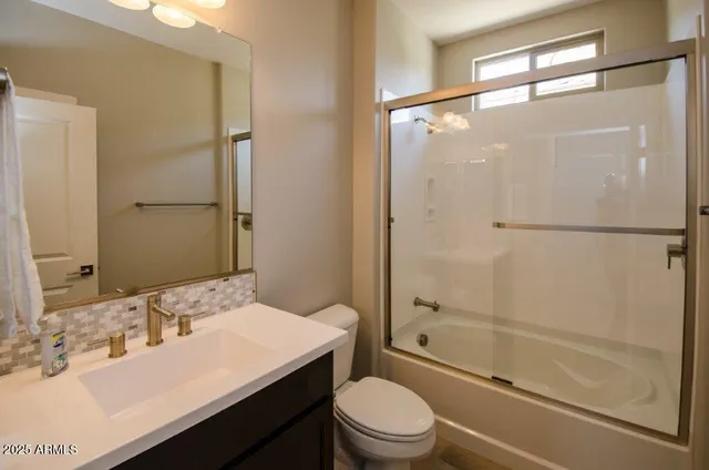 a bathroom with a sink a mirror toilet and shower